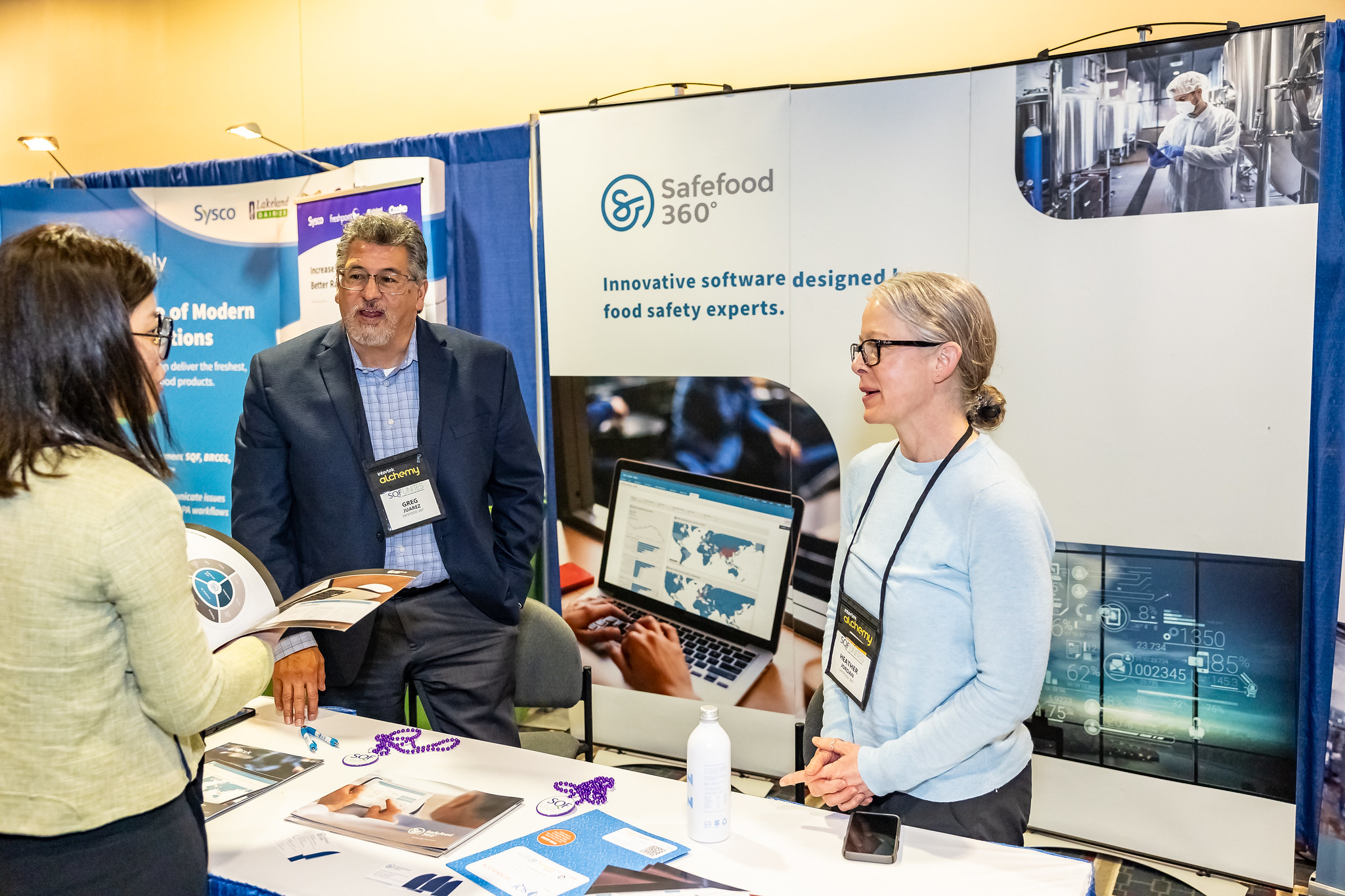 three people conversing in a booth